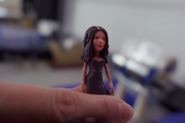 A Minikin figurine held between two fingers